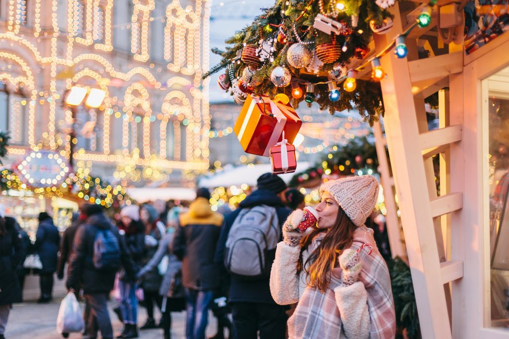 Woman Enjoys a Warm Holiday Drink While Out Shopping