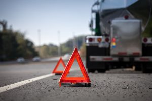 Road hazard reflectors warn others of a disabled truck off to the shoulder of the road.