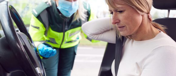 Female Paramedic Helping Female Driver With Whiplash Neck Injury Involved In Road Traffic Accident