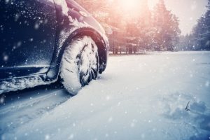 Car tires on winter road covered with snow.